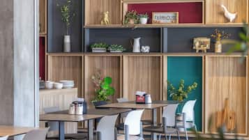 Un comedor moderno con estanterías de madera, un letrero que dice 'Eat' y varios objetos decorativos.