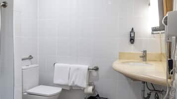 Un baño con inodoro, lavamanos y ducha.