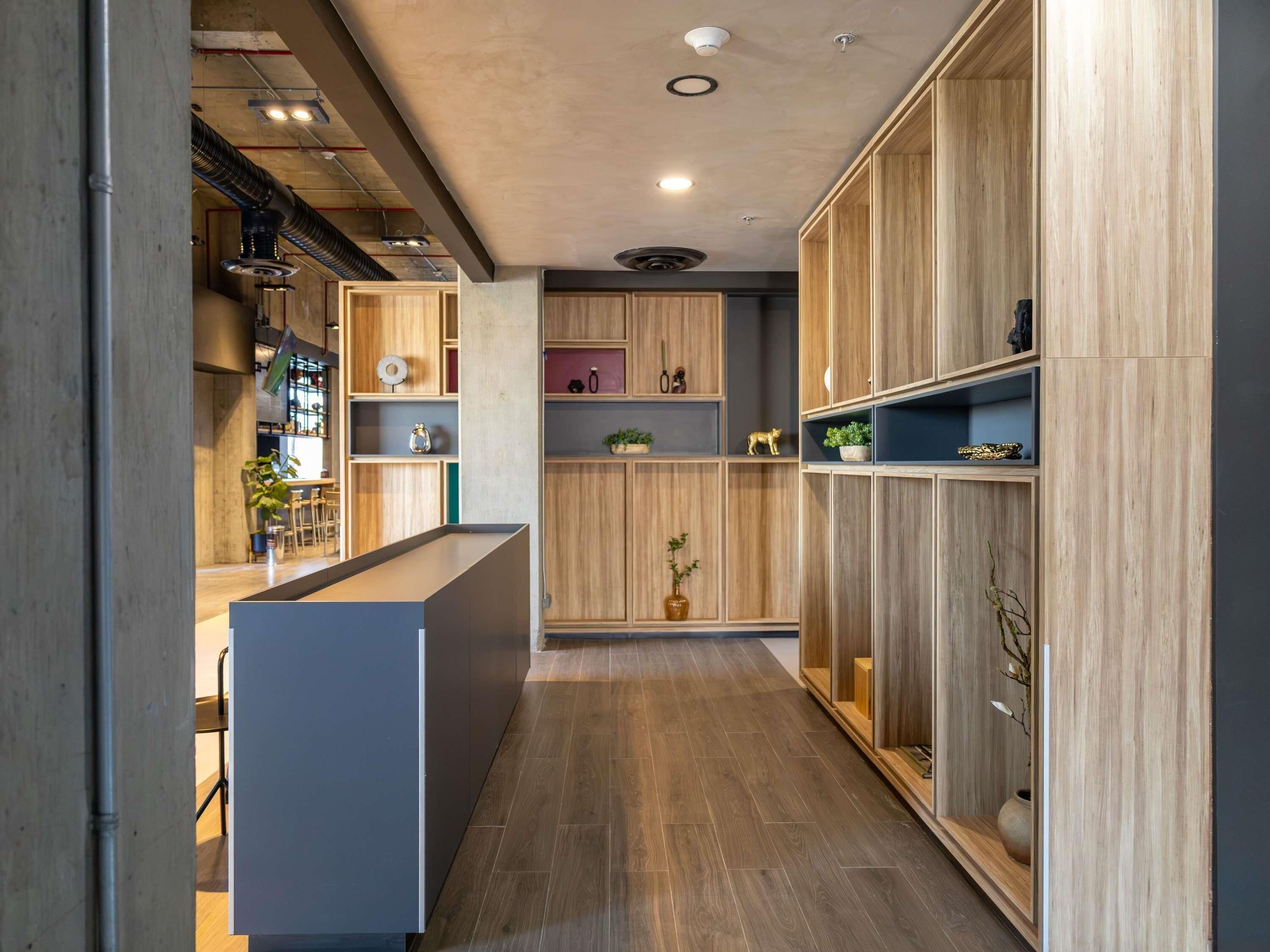 Una cocina moderna con armarios de madera, una isla central y estanterías empotradas.