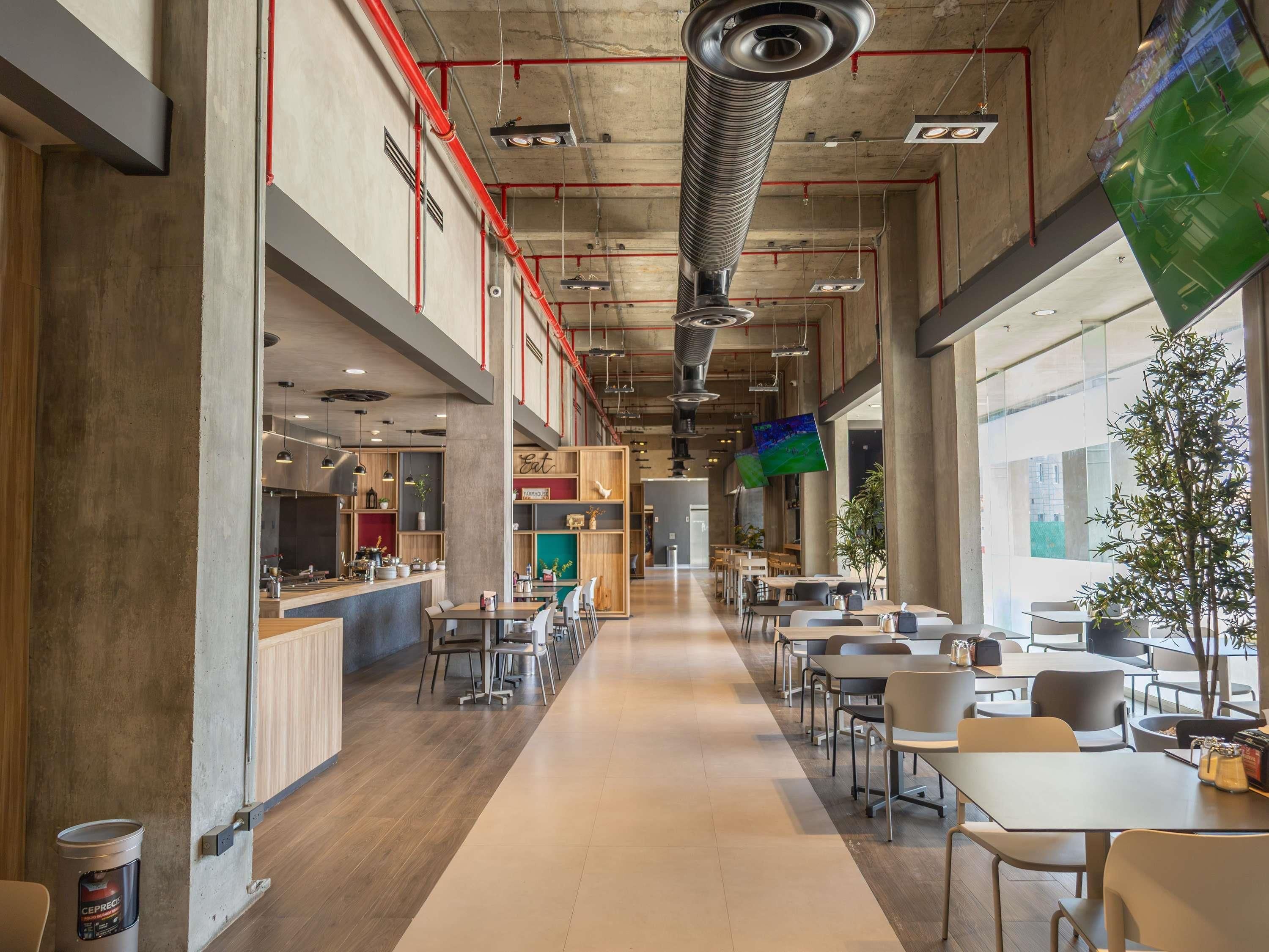 A spacious indoor area with a long counter, multiple tables, and chairs arranged for dining.