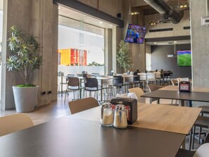 A modern dining area with tables, chairs, and a coffee machine.