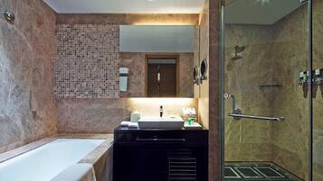 A modern bathroom with a bathtub, a vanity with a sink, a mirror, and a shower area.
