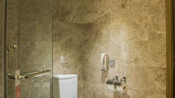 Un baño con ducha de vidrio, inodoro y bidé.