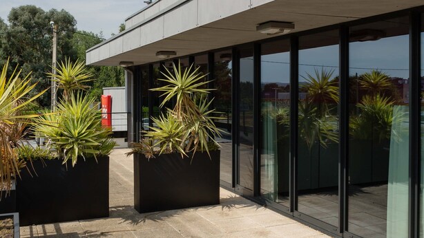 Un hôtel moderne, doté d'une enseigne rouge bien visible sur laquelle on peut lire « ibis HOTEL » et de grandes fenêtres en verre.