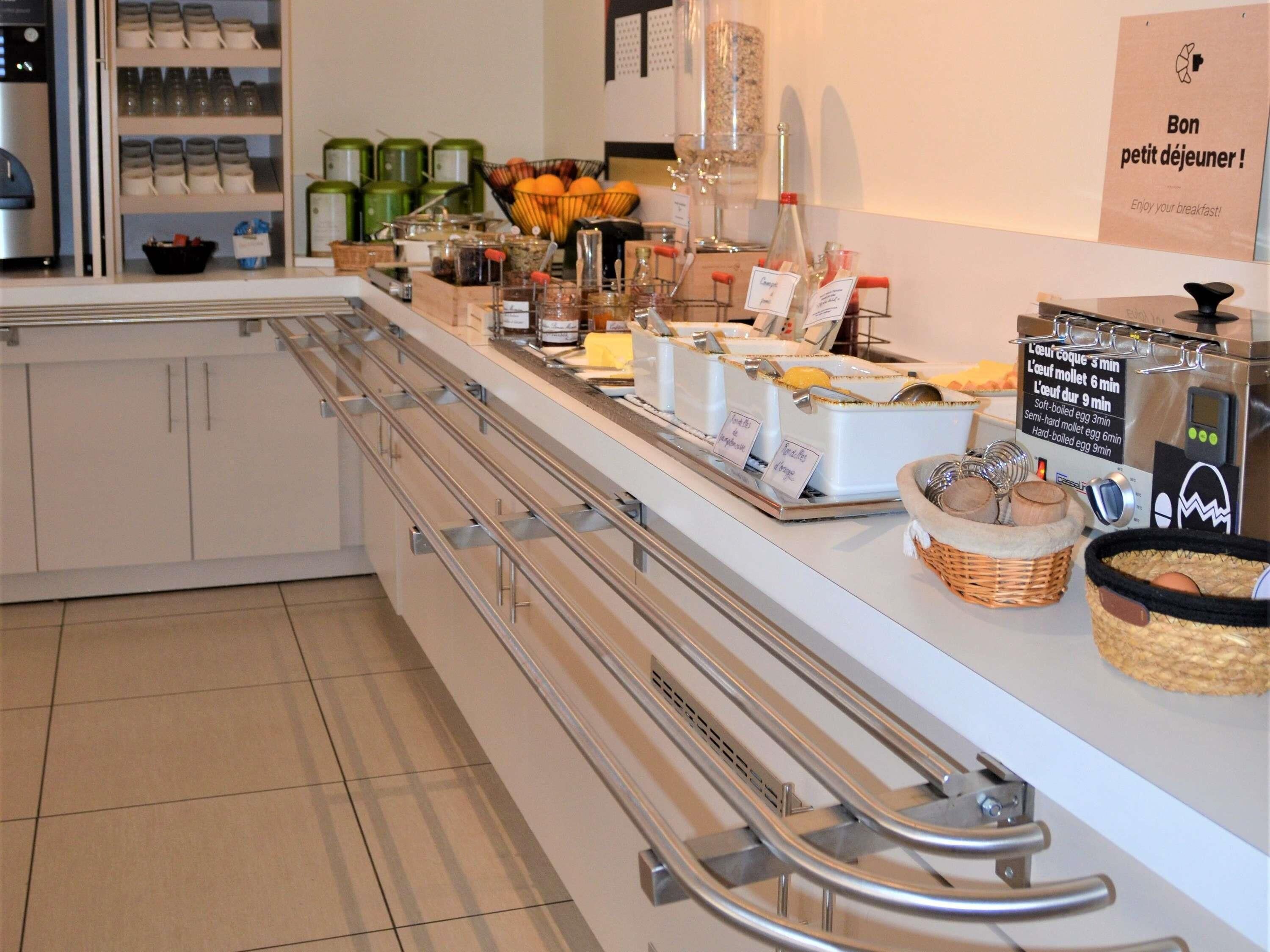 Zona de desayuno tipo buffet con diversas opciones de comida y una máquina de café.