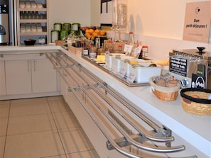 Un espace buffet pour le petit-déjeuner proposant divers aliments et une machine à café.