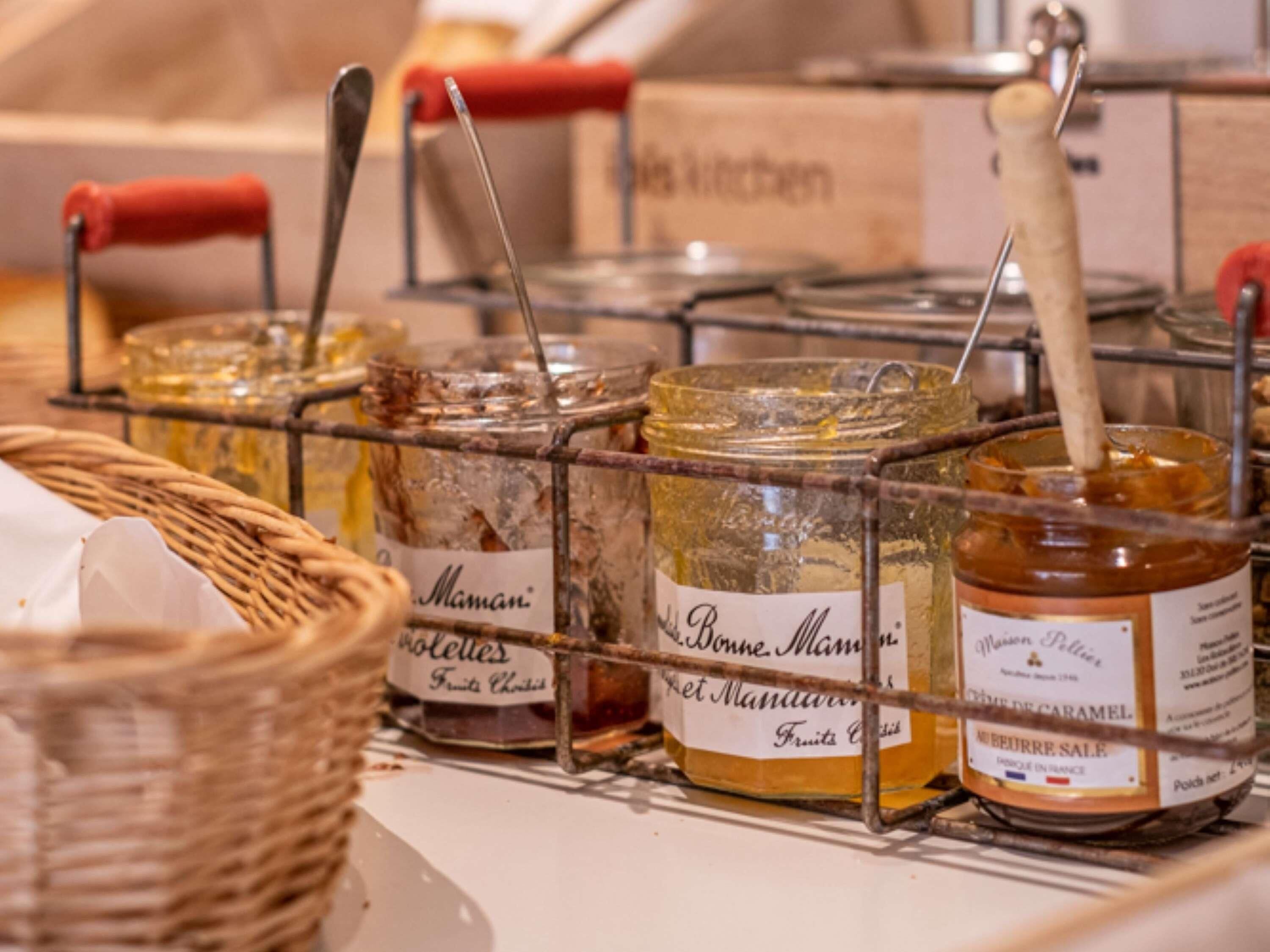 A display of various jars of preserves on a metal rack.