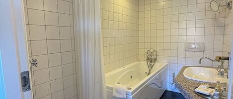 A bathroom with a bathtub, a shower, a sink, and a toilet.