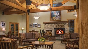 Una sala de estar acogedora con chimenea de piedra, muebles de madera y un cuadro en la pared.