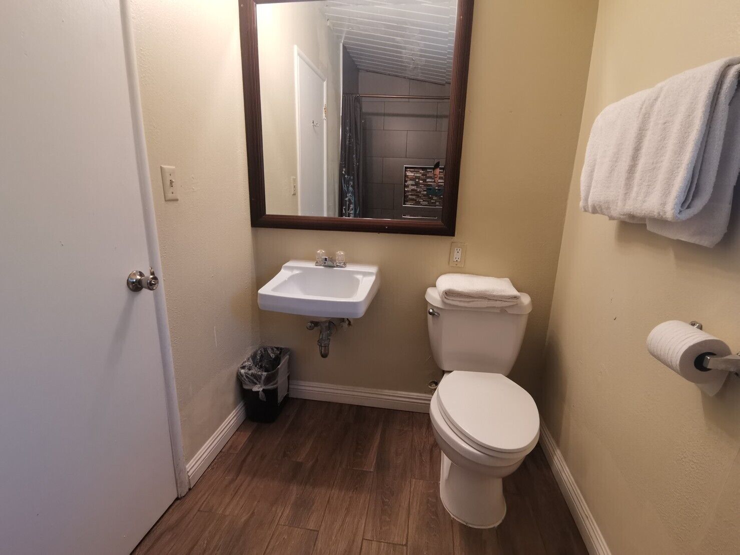 Ein kleines, sauberes Badezimmer mit Waschbecken, Toilette und Spiegel.