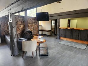 A modern interior with a stone wall, a fireplace, a wooden bar, and a seating area with a television. -  Studio 9 Big Bear (Big Bear Lake)