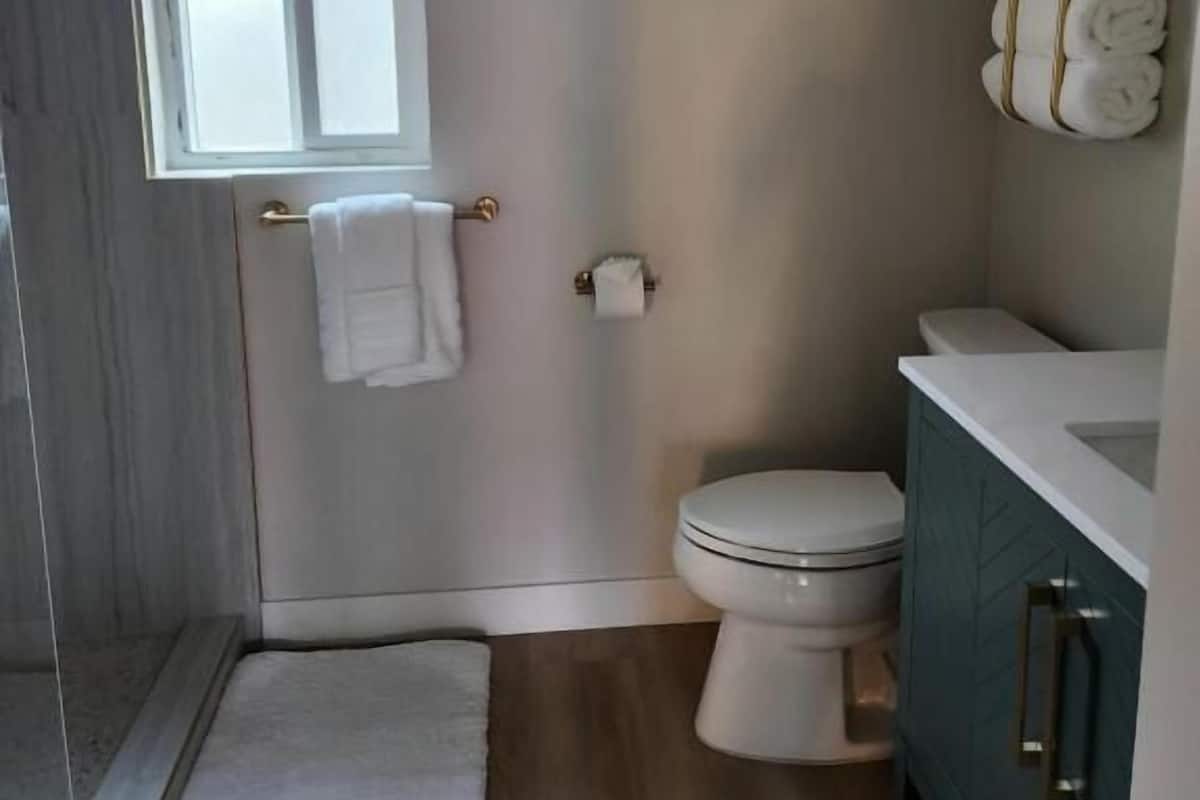 A compact bathroom with a toilet, a sink, and a window.