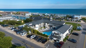 A hotel with a pool, multiple parking spaces, and a view of the ocean. - A Wave Inn (Montauk)