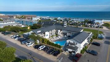 Un hotel con piscina, varios espacios de estacionamiento y vista al océano.