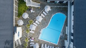 An aerial view of a swimming pool area with lounge chairs and umbrellas. - A Wave Inn (Montauk)