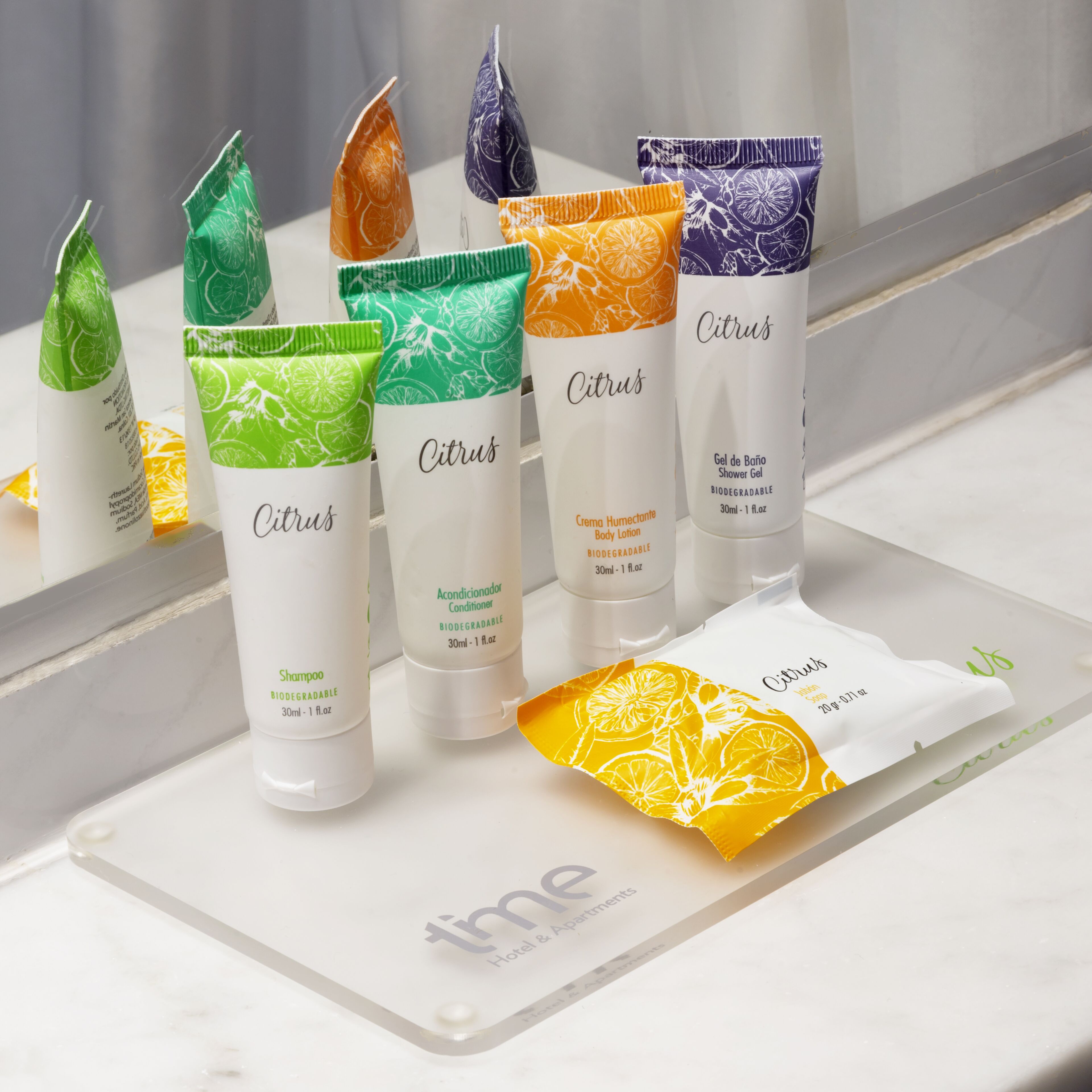 A bathroom with toiletries including shampoo, conditioner, body lotion, and shower gel.