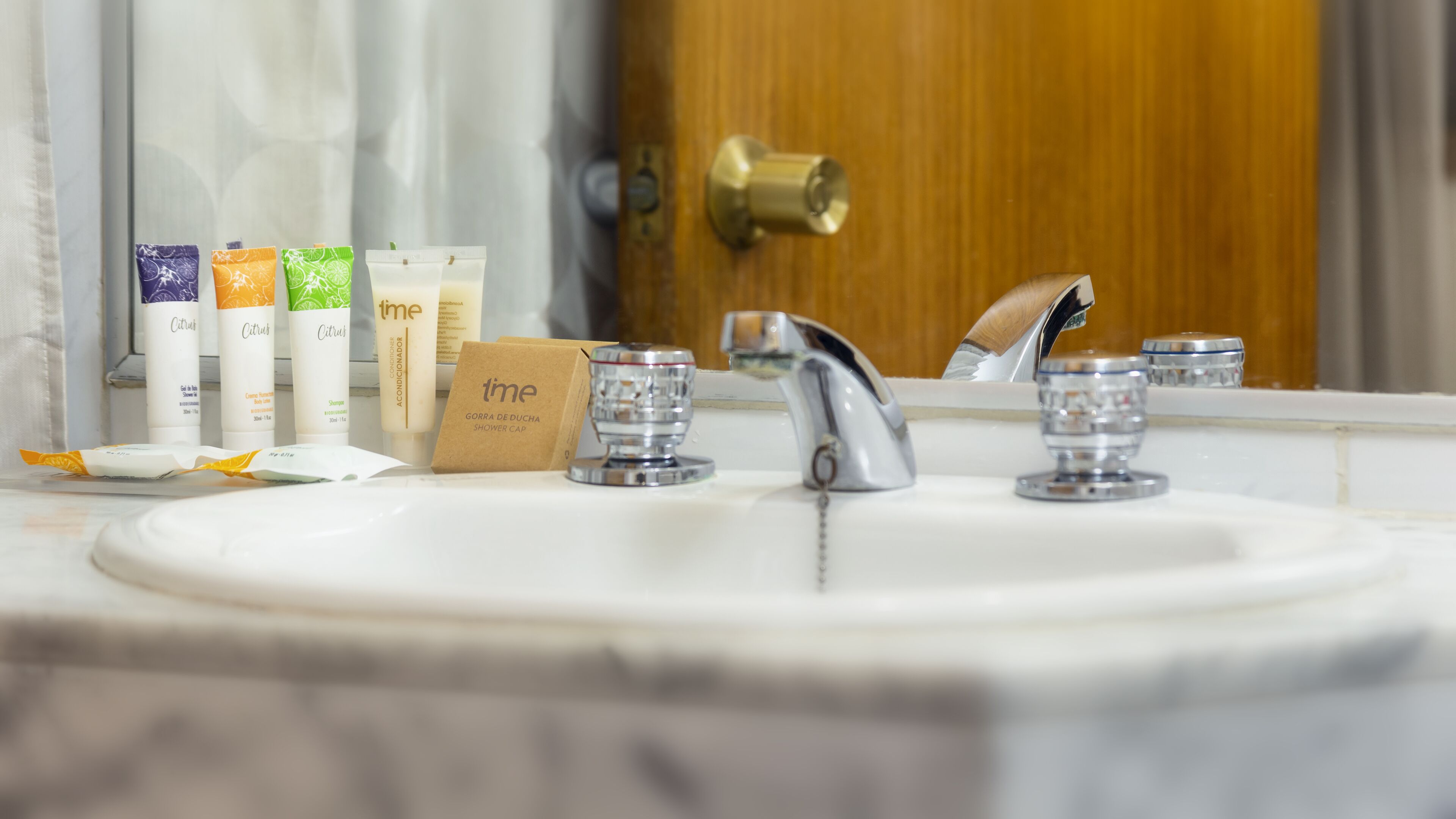 Un lavabo de salle de bain avec des articles de toilette et un bonnet de douche.
