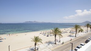 Una playa con aguas azules cristalinas, palmeras y una carretera con bicicletas.