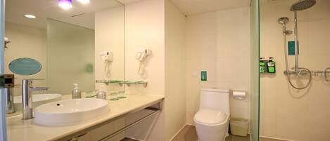 Une salle de bain moderne équipée d’un lavabo, de toilettes et d’une douche.