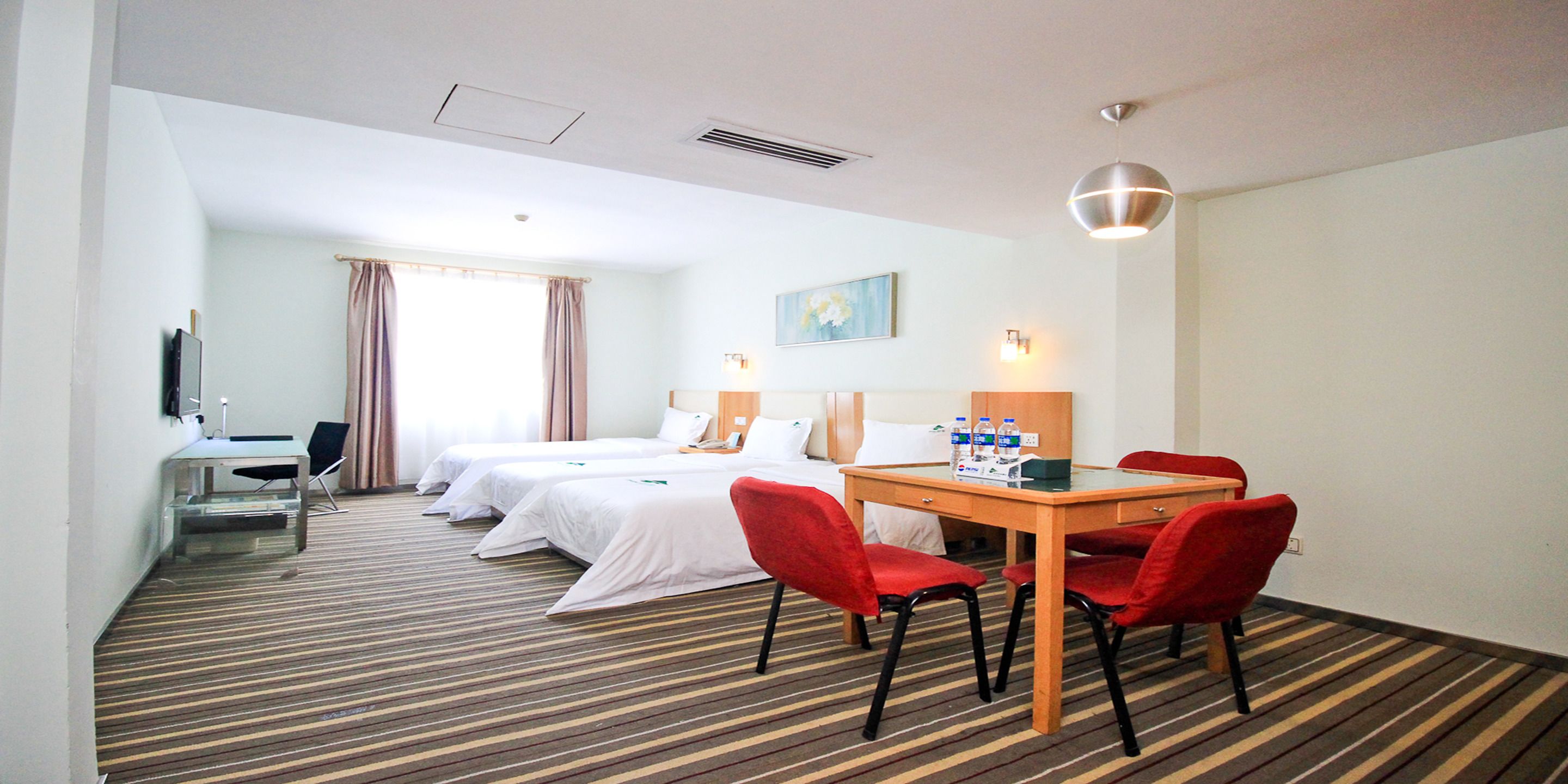 Une chambre d’hôtel avec deux lits, un bureau, une chaise, une table et une lampe.