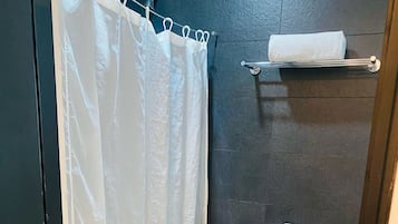 Un baño pequeño con inodoro blanco, cortina de ducha y barra para toallas.