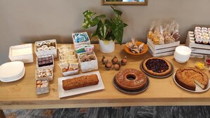 A buffet table with various food items including pastries, cakes, and fruits. - Trieste (Morbegno)