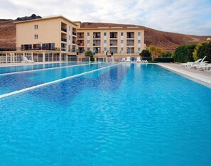 A swimming pool with a building in the background.