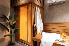 A wooden bench with a white towel, a glass of orange juice, and a book on a wooden table.