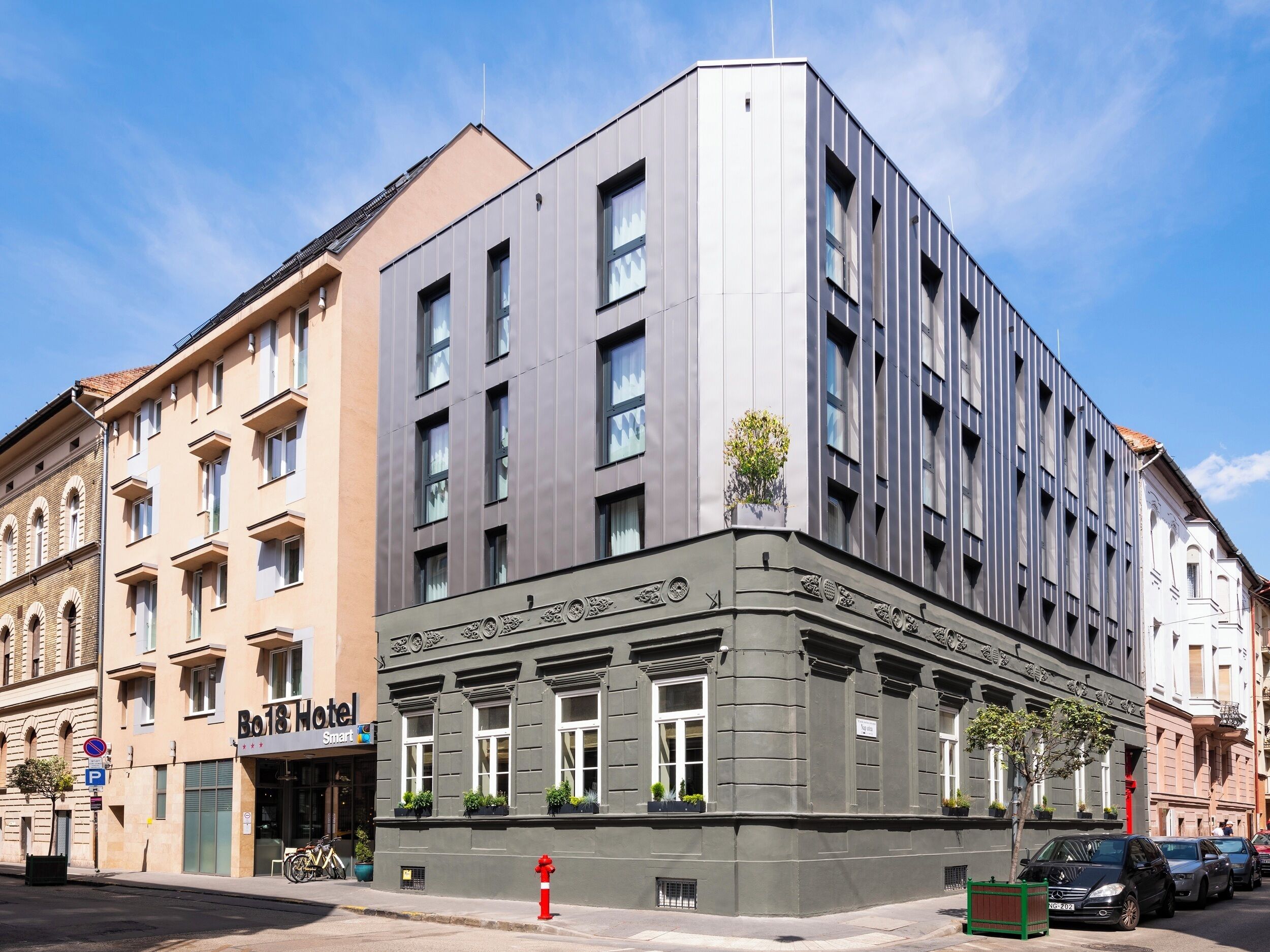 A hotel with a modern facade, large windows, and a corner entrance.
