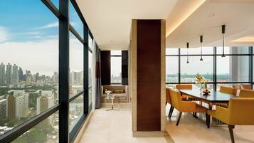 Um interior moderno com área de jantar, um sofá e vista para a cidade.