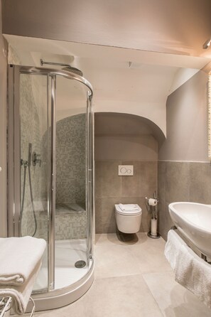 A modern bathroom with a glass-enclosed shower, a toilet, and a sink. - Badia Fiorentina (Florence)