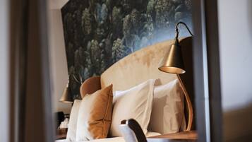 A modern bedroom with a large bed, a headboard, and a bedside lamp.