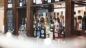 Uma área de bar com diversas garrafas de bebidas alcoólicas nas prateleiras.