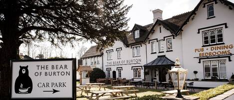 A building with a sign for "The Bear of Burton Car Park" and "Pub, Dining, Bedrooms" indicating it is a multi-purpose establishment.