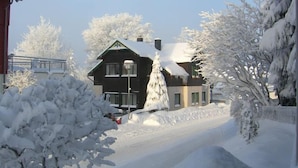 A snow-covered residential area with houses, a street, and a fence. - Oberhof 810 M (Oberhof)