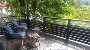 A balcony with wicker chairs and a small table, surrounded by a black railing. - Oberhof 810 M (Oberhof)