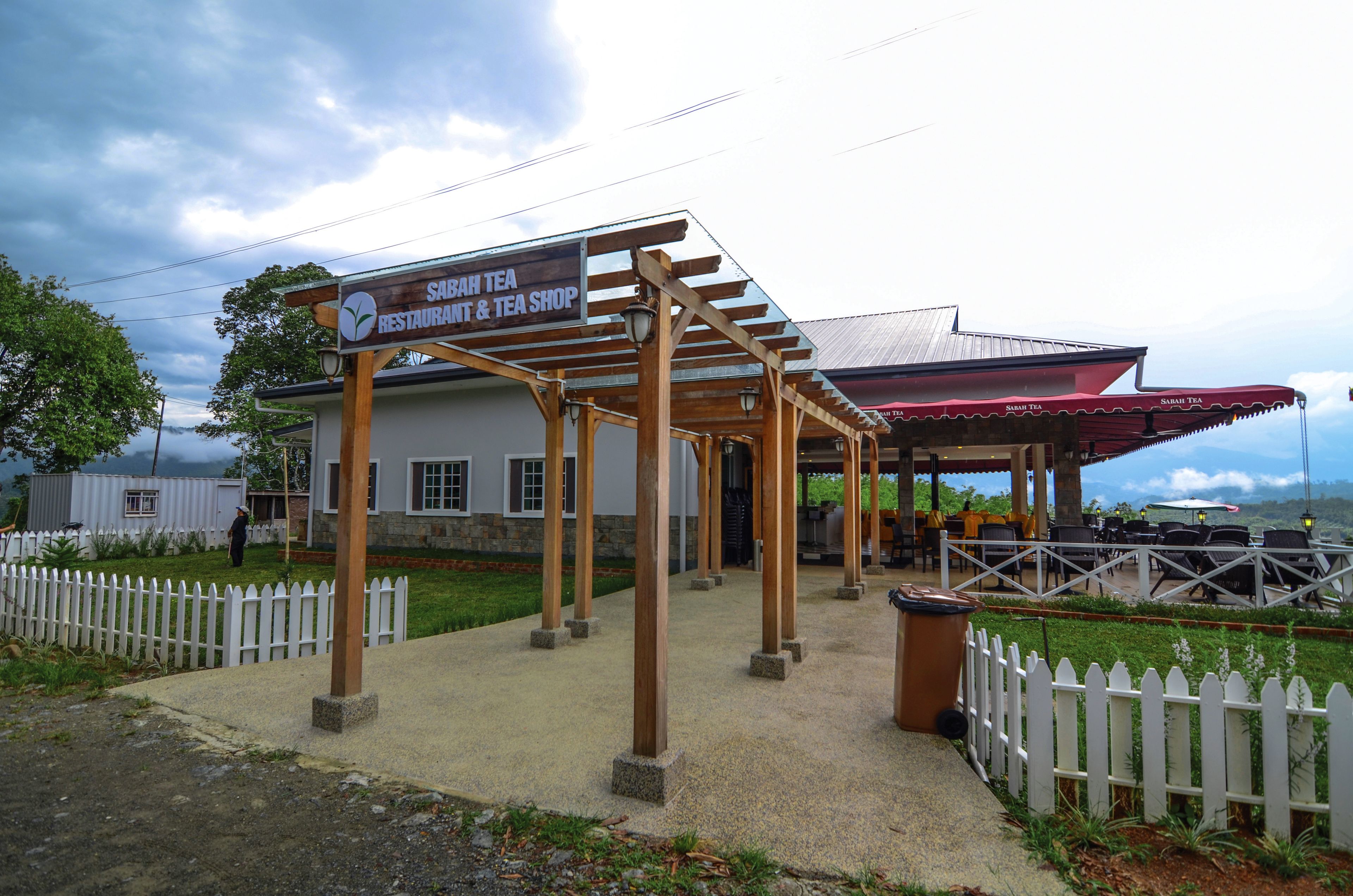 Un espacio de estar al aire libre cubierto con un cartel que dice 'Sah Tea Restaurant & Tea Shop'.