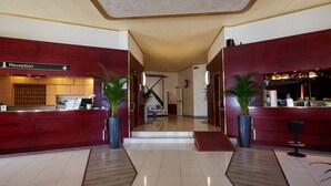 A reception area with a reception desk, a staircase, and potted plants. - Hotel Atlantic (Arona)