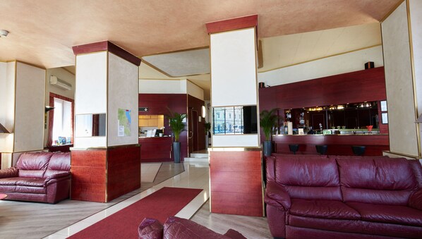 A lobby with leather sofas, a reception desk, and a bar area. - Hotel Atlantic (Arona)