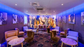 A jazz-themed room with a stage, seating, and wall art. - B&B HOTEL Colmar Liberté 4 étoiles (Colmar)