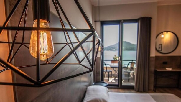 A hotel room with a bed, a desk, and a view of the outdoors. - Hotel Concorde (Arona)