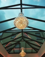A modern interior with a glass ceiling and a chandelier.