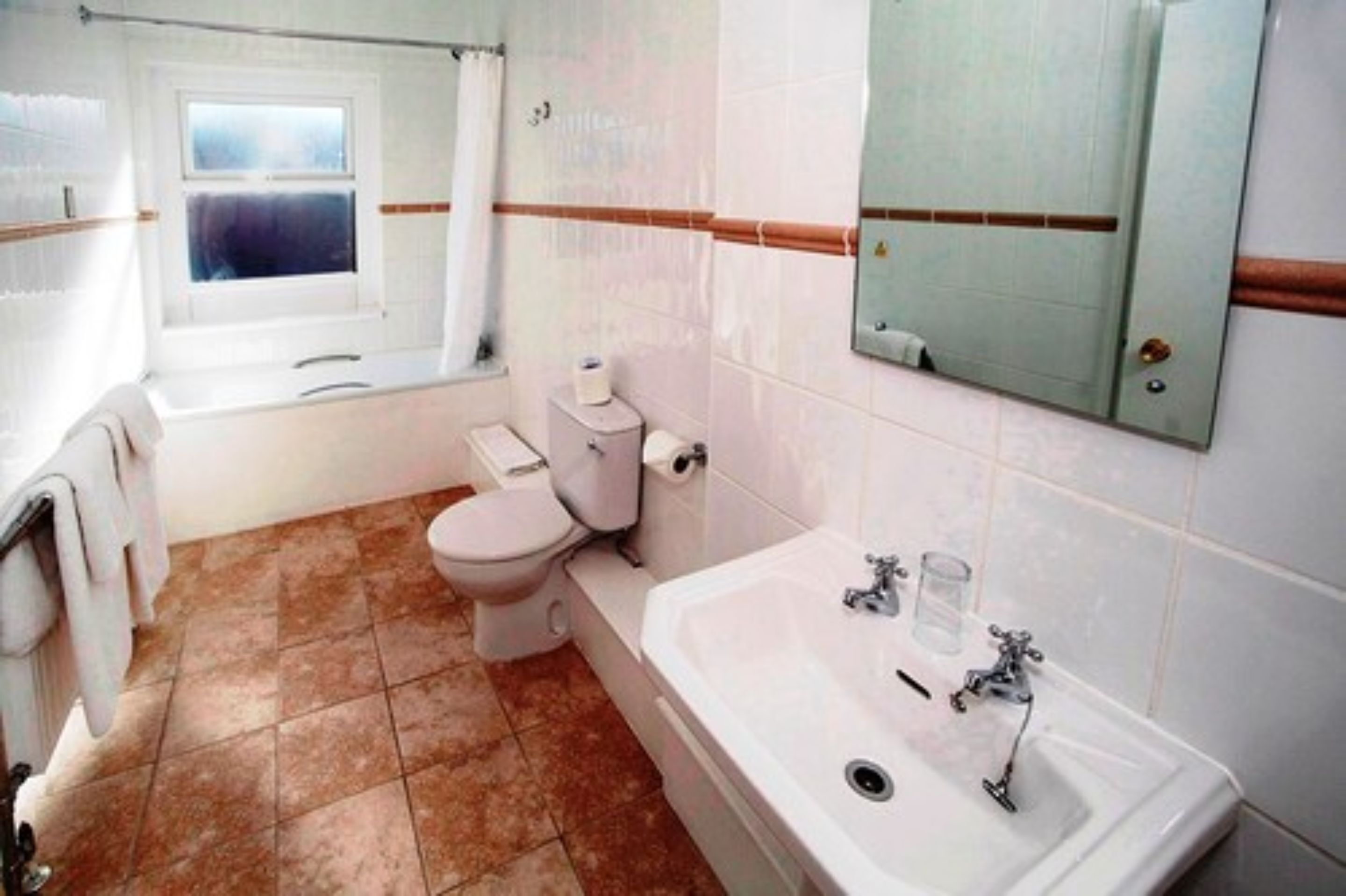 A bathroom with a bathtub, toilet, and sink.