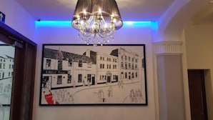 Un dibujo en blanco y negro enmarcado de una escena callejera con edificios y personas, colgado en una pared.