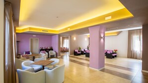 A modern hotel lobby with a central seating area, a reception desk, and a large window. - Lory (Chianciano Terme)