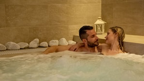 A couple in a hot tub with a tiled wall and a lantern in the background. - Lory (Chianciano Terme)