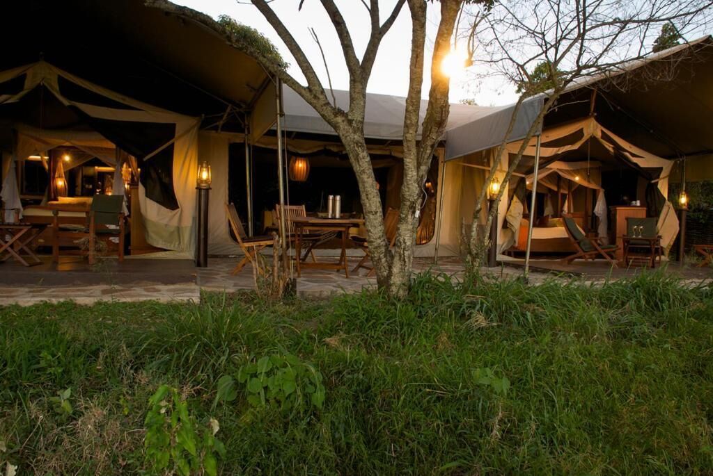 A tented accommodation with outdoor seating and ambient lighting.