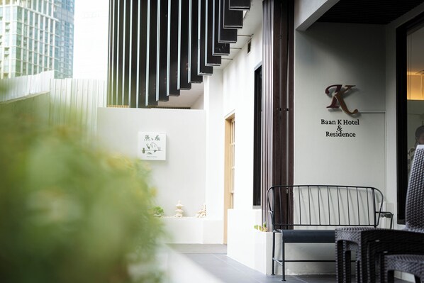 Un moderno vestíbulo de hotel con una escalera, una recepción y un letrero de Baan K Hotel & Residence.