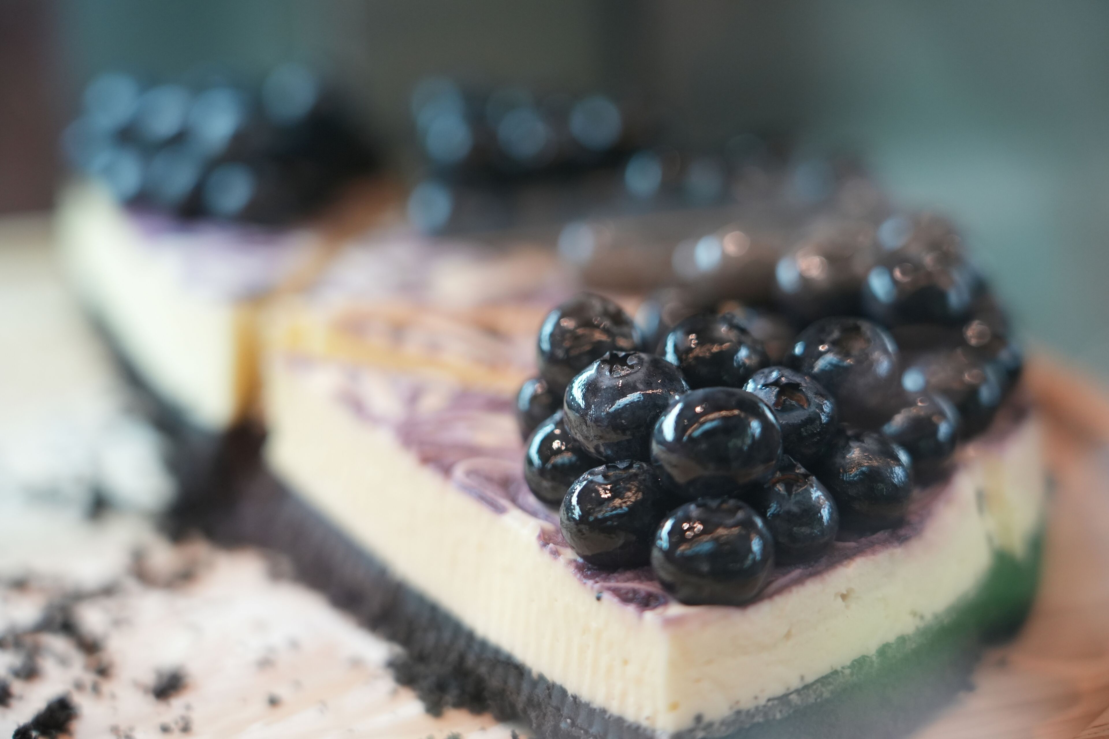 Una porción de pastel con capas y arándanos encima.
