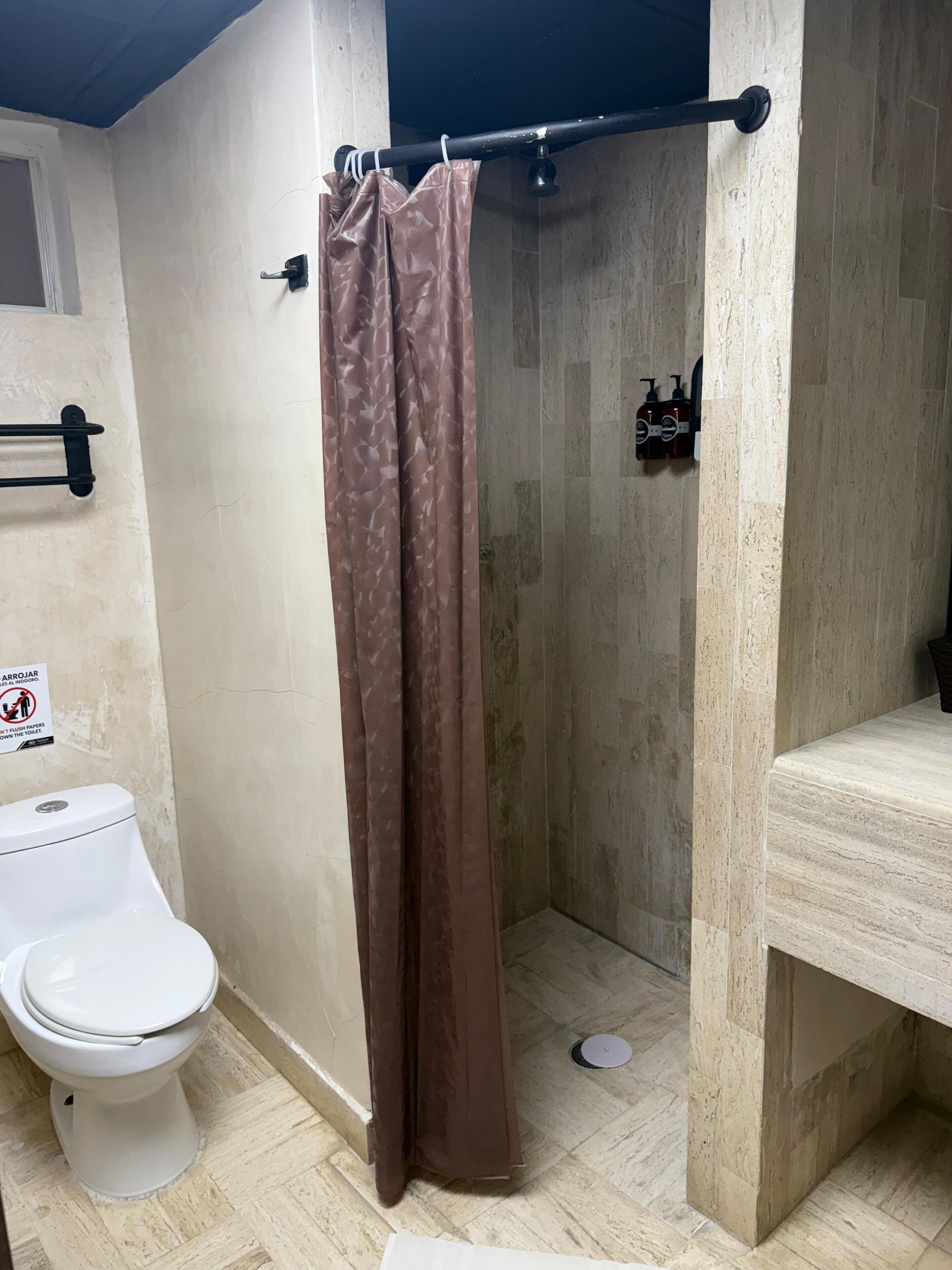 Un baño con inodoro, ducha y lavamanos.